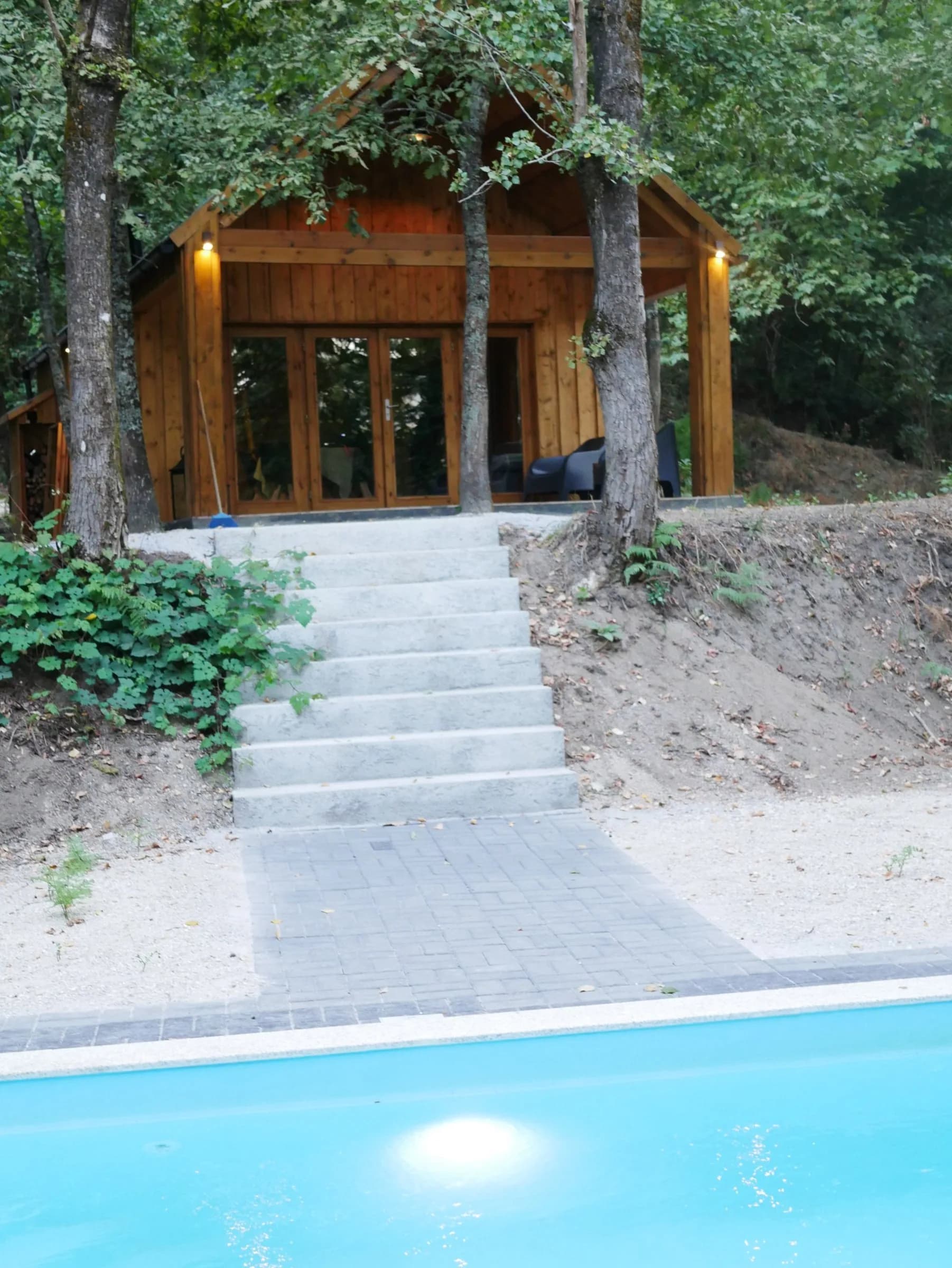 A cabana vista da piscina, com a escada de pedra