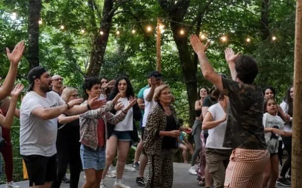 Convívio a dançar na zona de piquenique, sob luzes de arraial